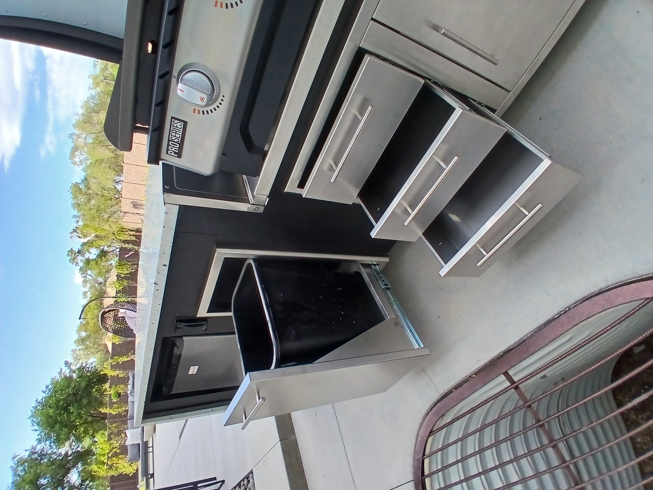 Outdoor kitchen with storage and trash pullout